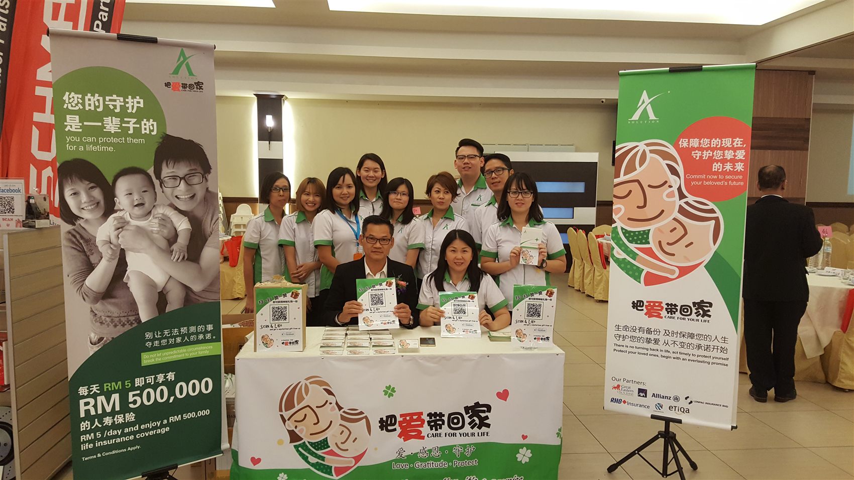 A SOLUTION 团队在活动现场,背景横幅:把爱带回家